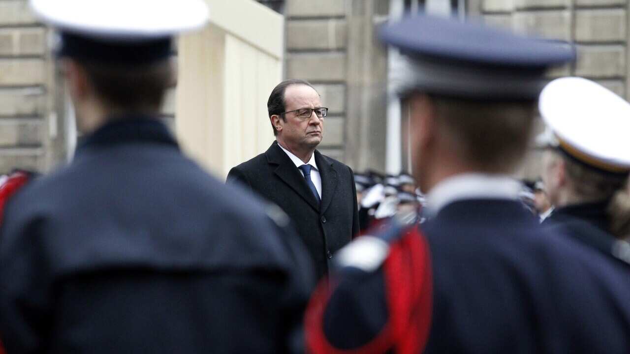 French president Francois Hollande reviews the troops, on January 13, 2015 at the Paris' prefecture, during a ceremony to pay tribute to the three police officers killed in the attacks.