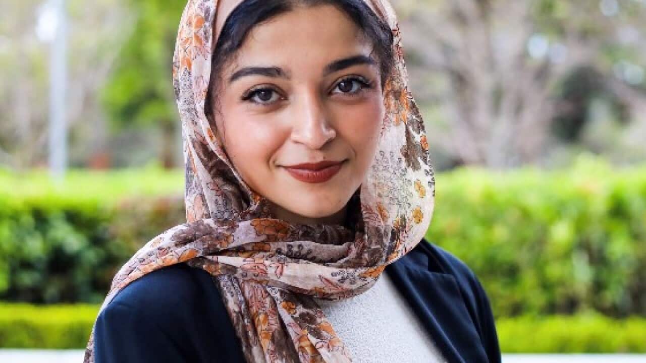 A woman wearing a hijab smiling.