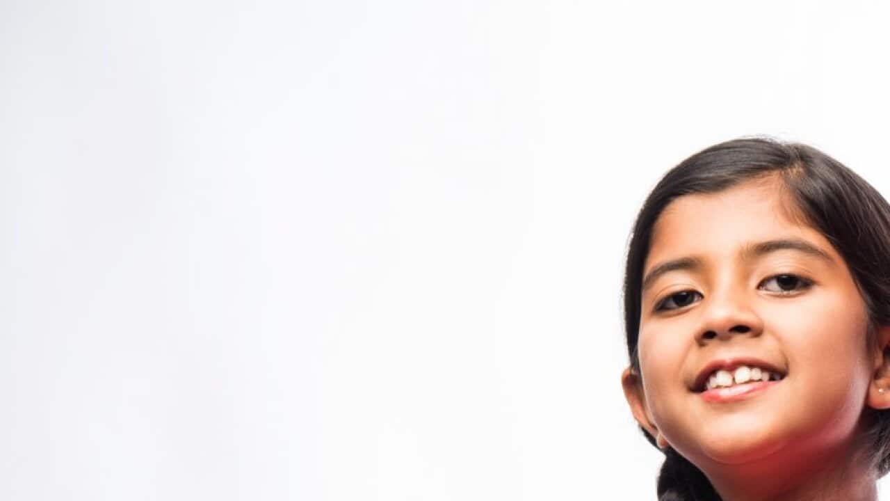 Cute little sikh/punjabi boy and girl standing isolated over white background, facing camera