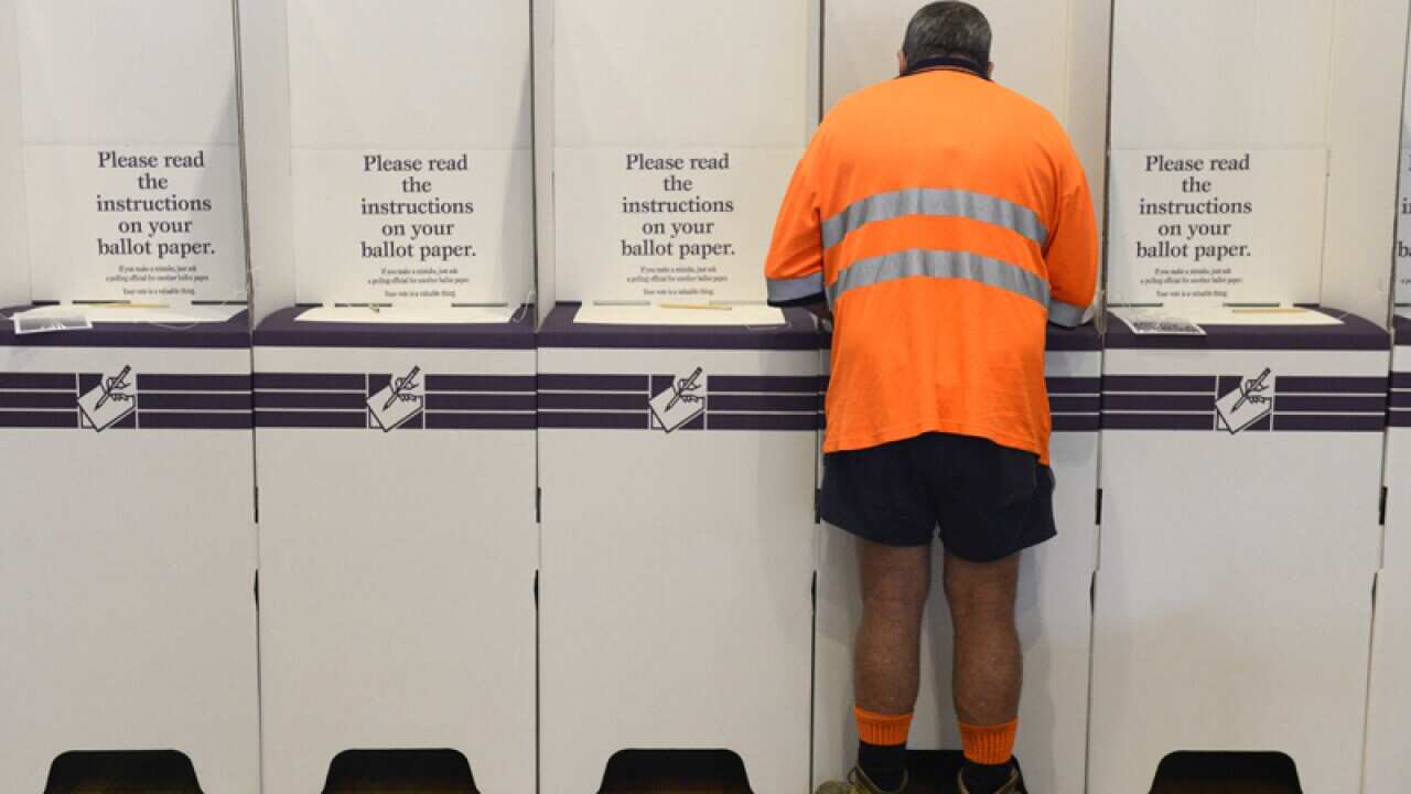 A voter makes his choice in a polling booth