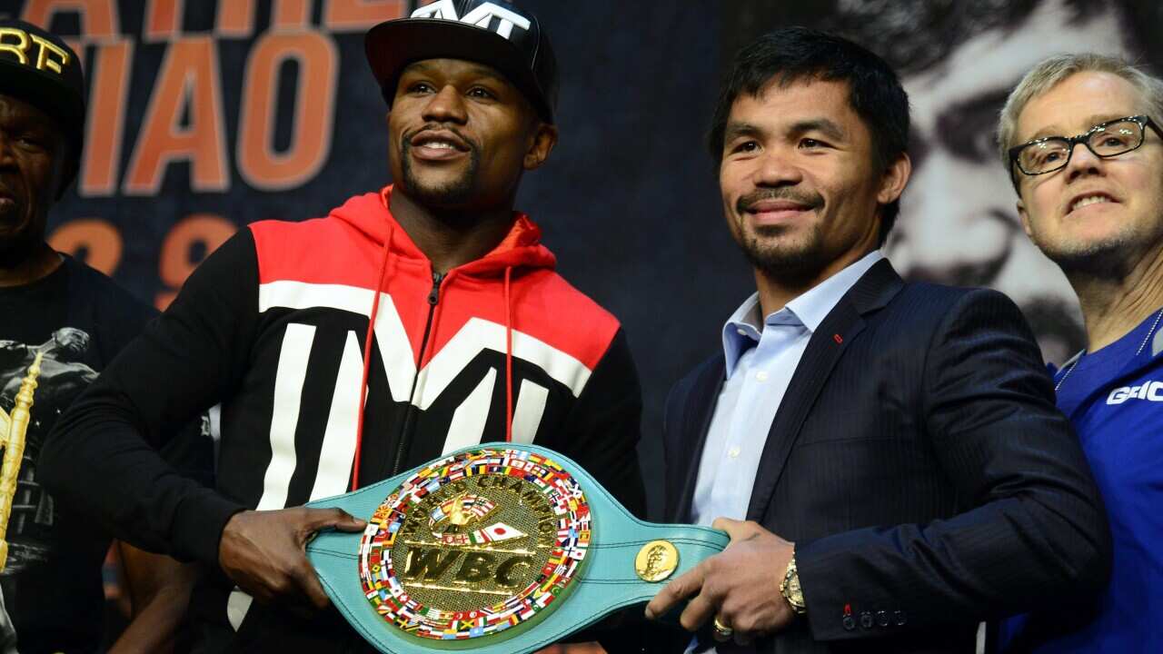Manny Pacquiao (R) and Floyd Mayweather Jr (L) hold the WBC welterweight 'Emerald' belt.