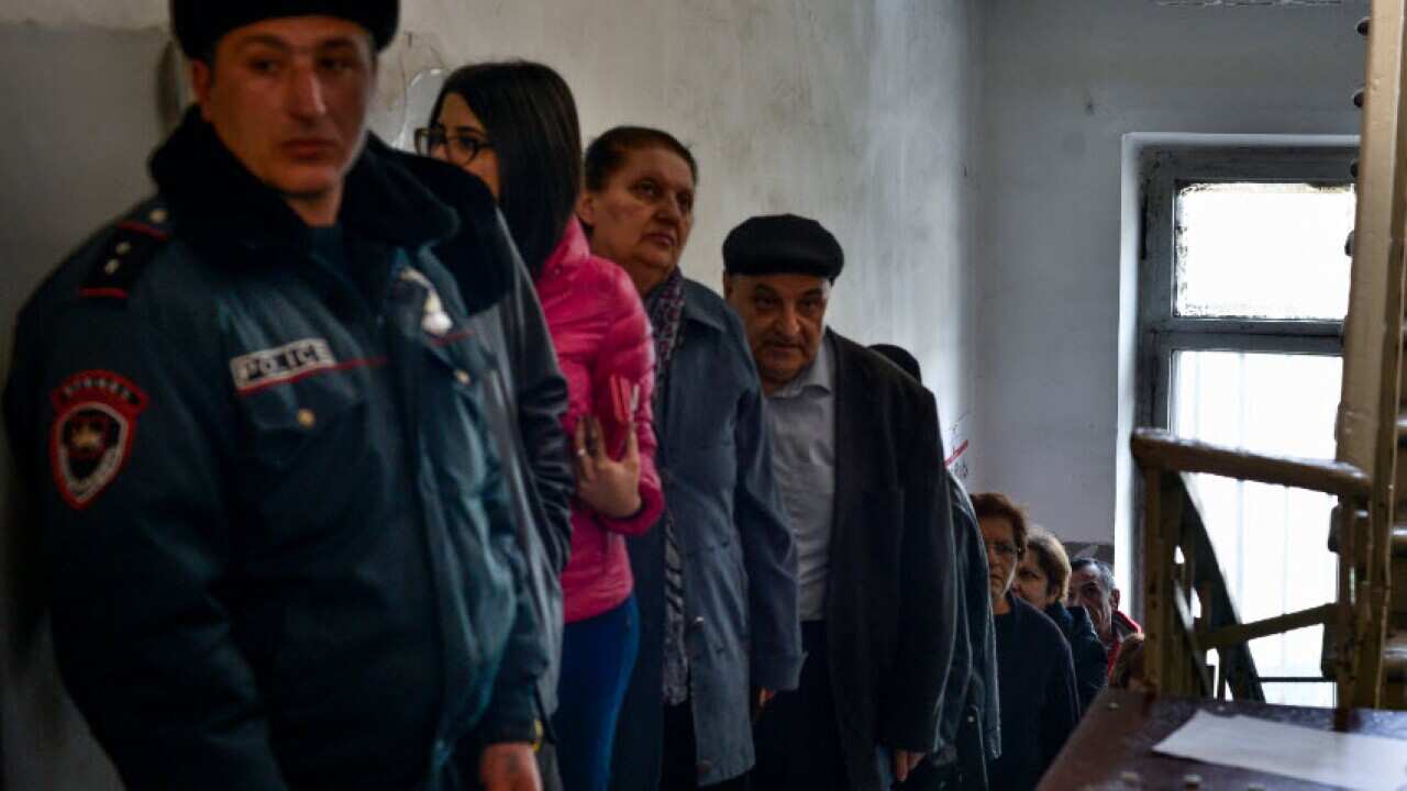 Armenians line up to vote at a polling station during a parliamentary election in Yerevan, Armenia, Sunday.