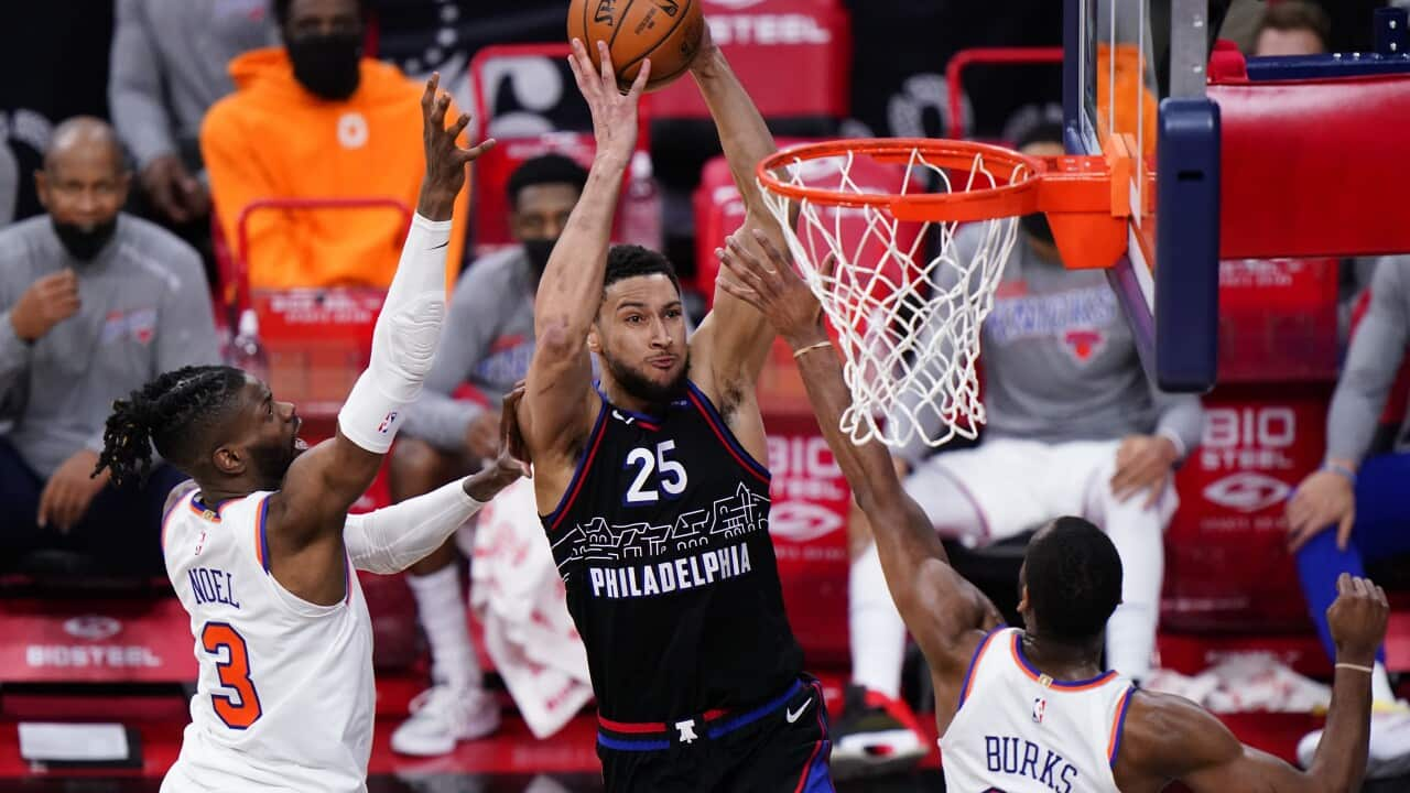 Philadelphia 76ers' Ben Simmons (25) goes up for a dunk between New York Knicks' Nerlens Noel (3) and Alec Burks (18) during the second half of an NBA basketball game, Tuesday, March 16, 2021, in Philadelphia. (AP Photo/Matt Slocum)