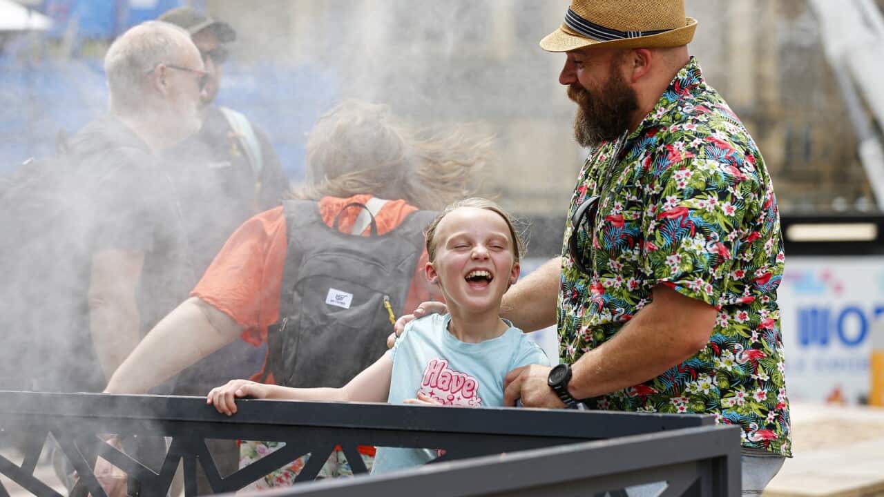 People enjoy mist cooling fans in Melbourne on a 43 degree day (AAP)
