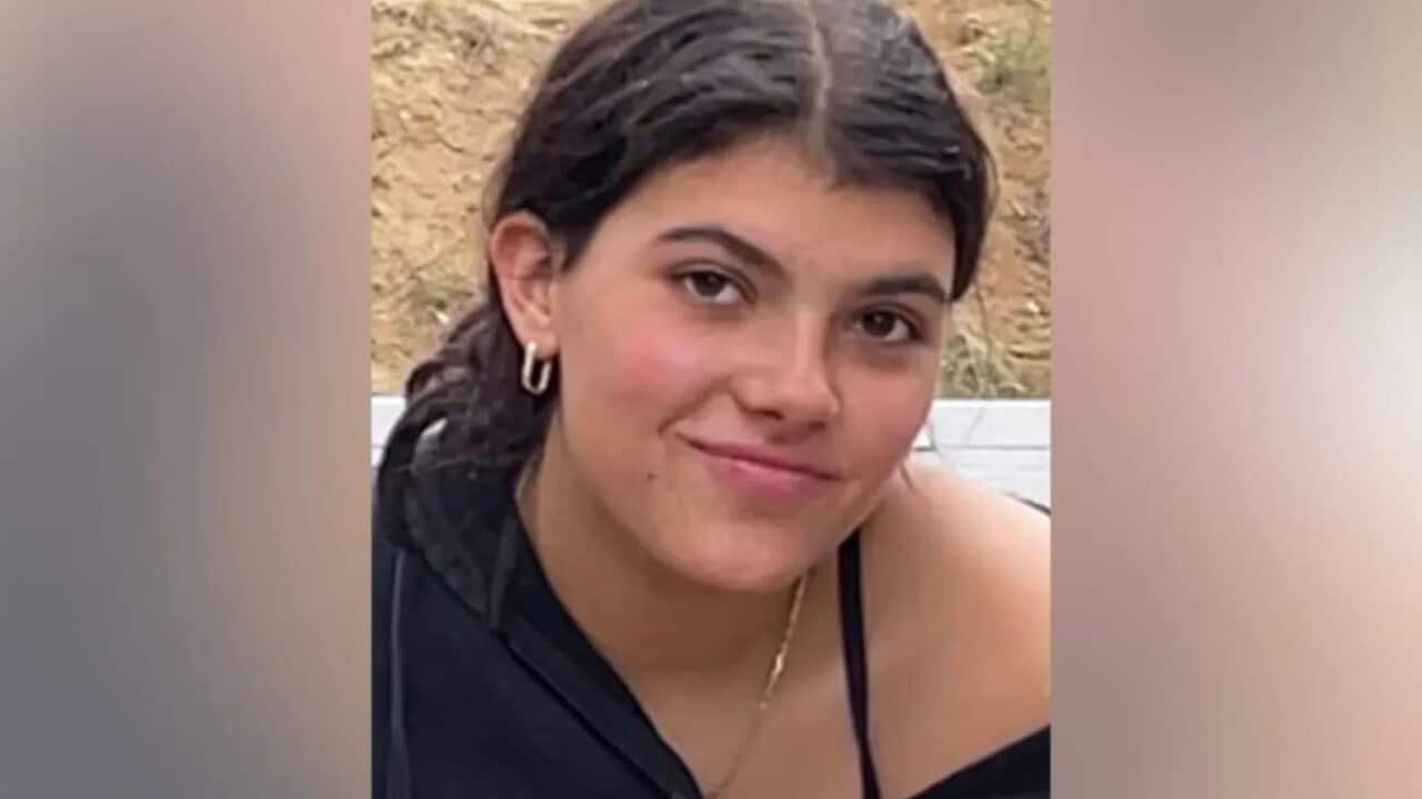 A young white woman with brown hair smiling