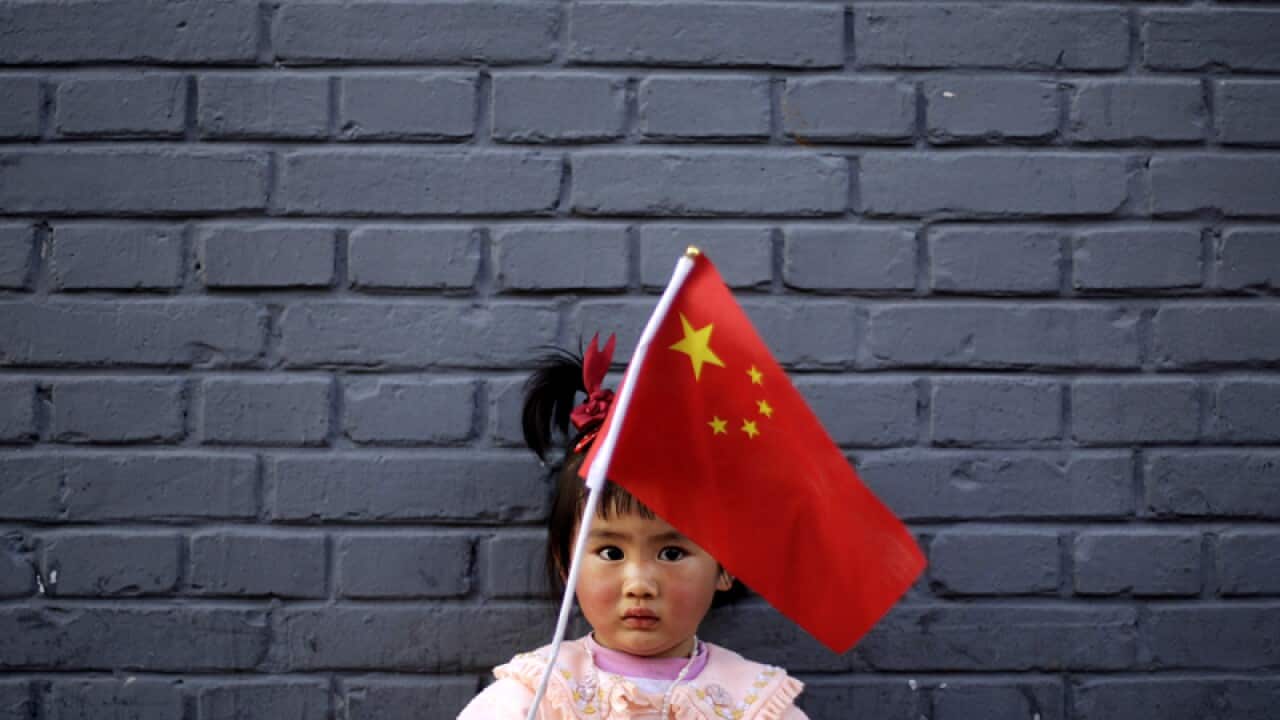A young Chinese girl plays with a Chinese flag