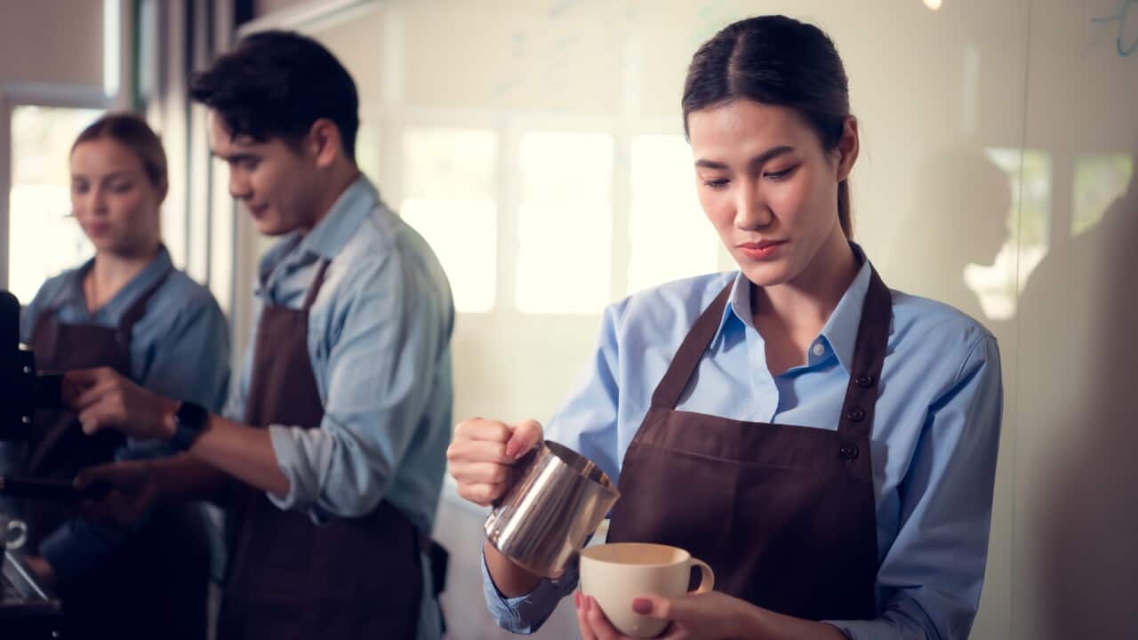 Young female barista adept in champion coffee brewing, creating