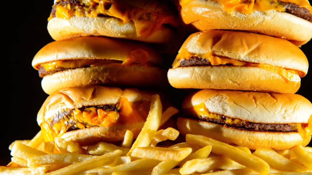 A pile of cheeseburgers and french fries