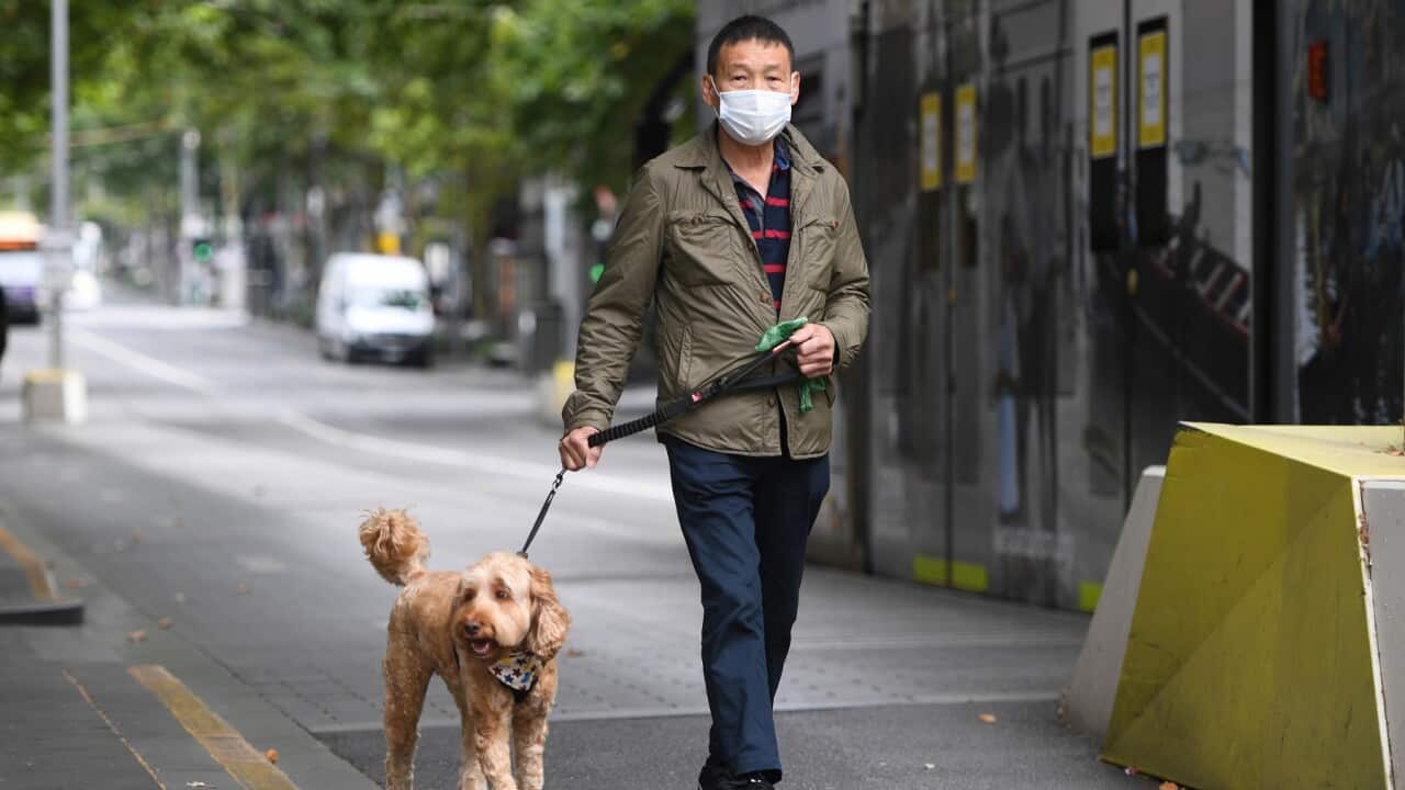People are seen wearing masks in Melbourne, Saturday, February 13, 2021. Victoria has entered a "short, sharp circuit-breaker" lockdown for five days amid fears the highly infectious UK strain of coronavirus has spread in the community. (AAP Image/Erik An