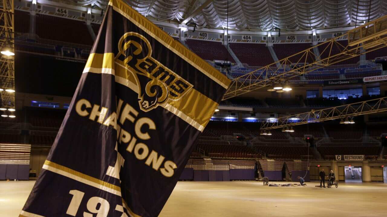 A Rams championship banner is removed from the Edward Jones Dome