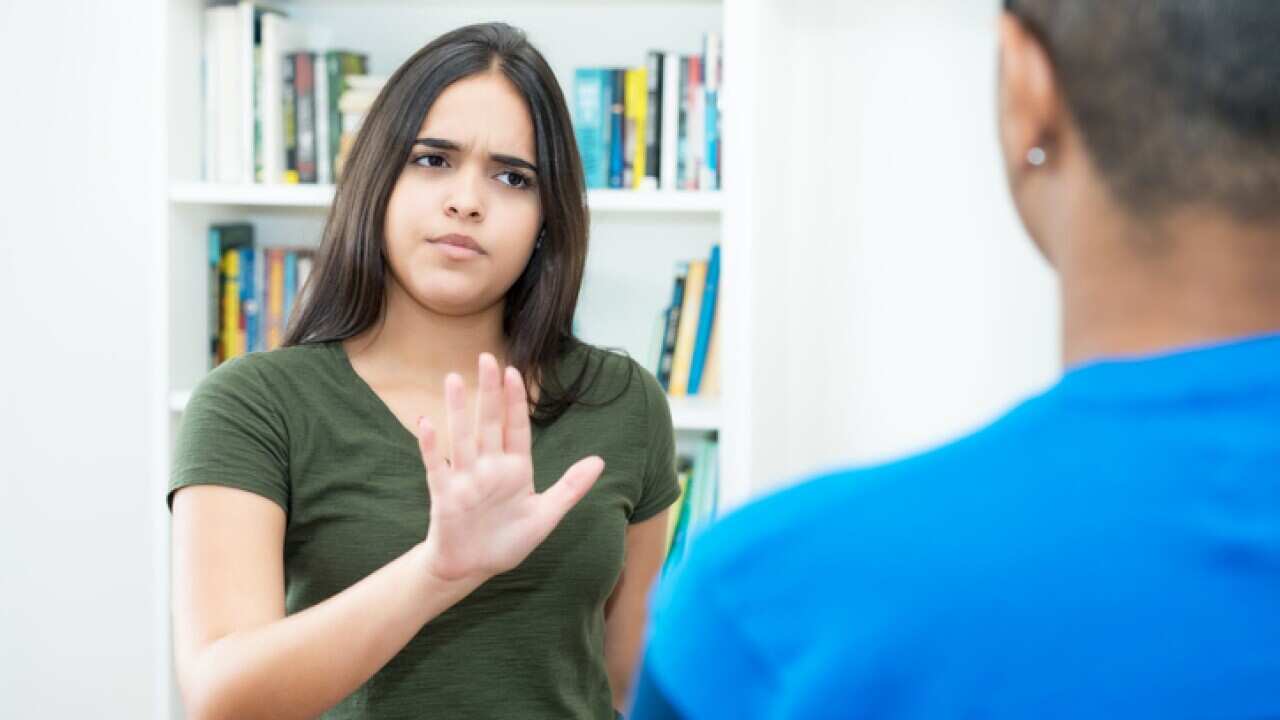 Hispanic female young adult gesturing stop and social distancing