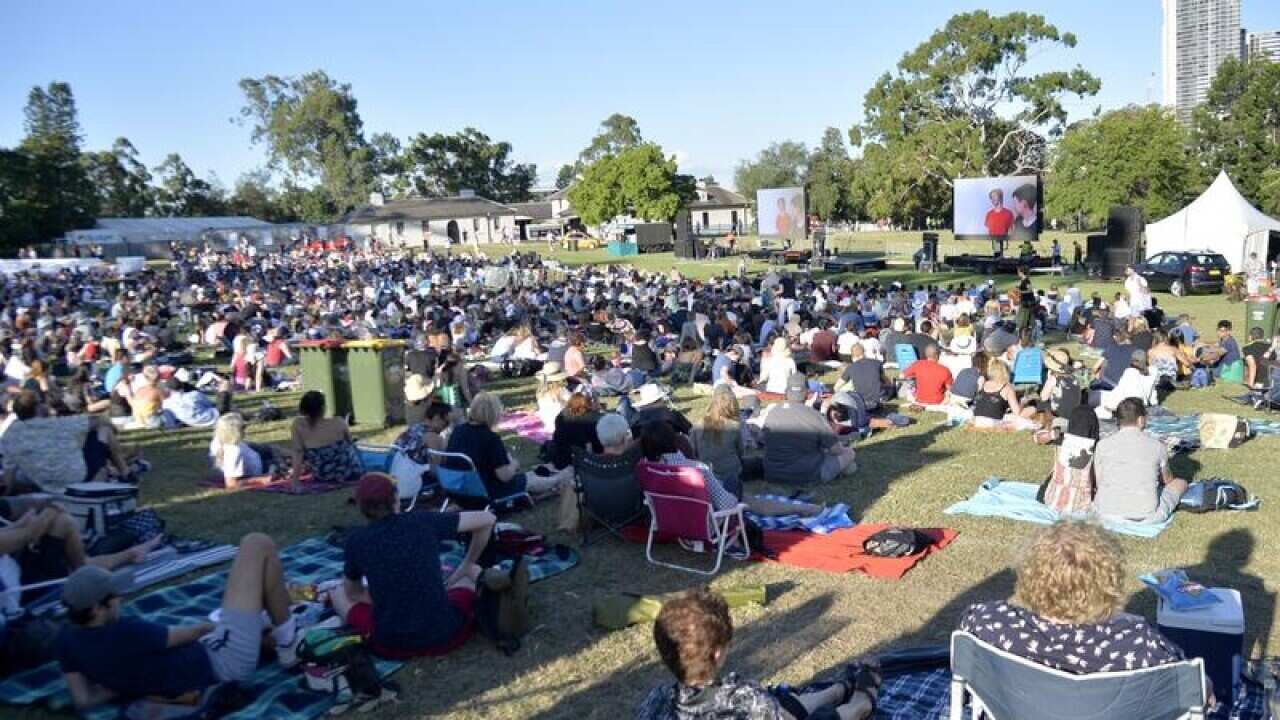Moviegoers gather on the grass.