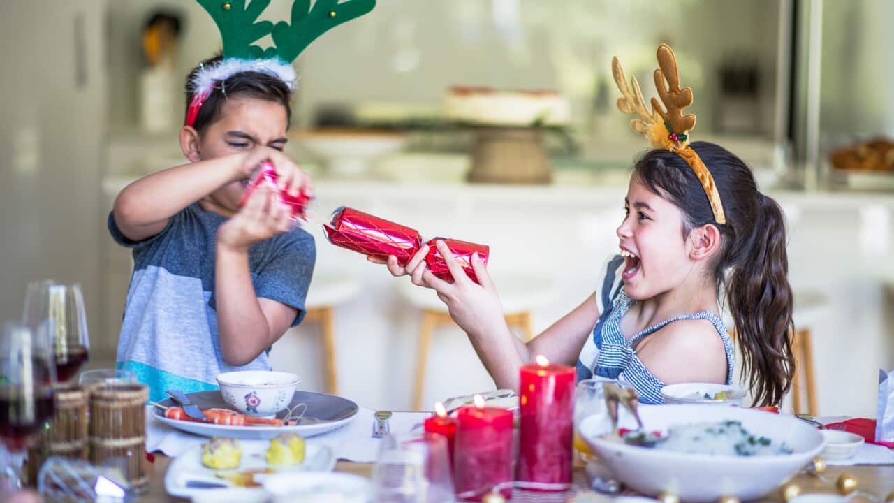 Australian children at home pulling christmas cracker at table