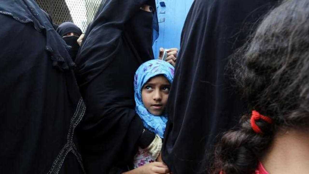 A young Yemeni girl waits amongst the crush of women lining up to receive free bread at a charity bakery during a severe shortage of food in Sana'a, Yemen,