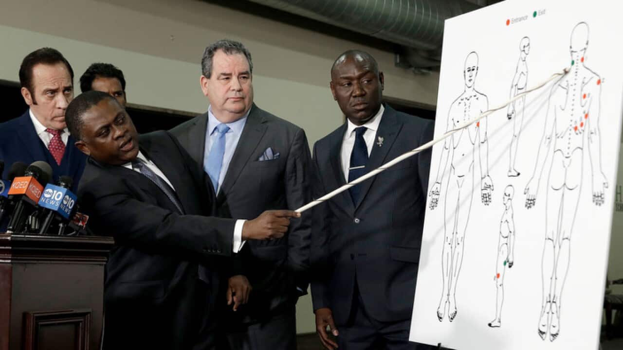 Pathologist, Dr. Bennet Omalu, second from left, gestures to a diagram showing where police shooting victim Stephon Clark was struck by bullets.