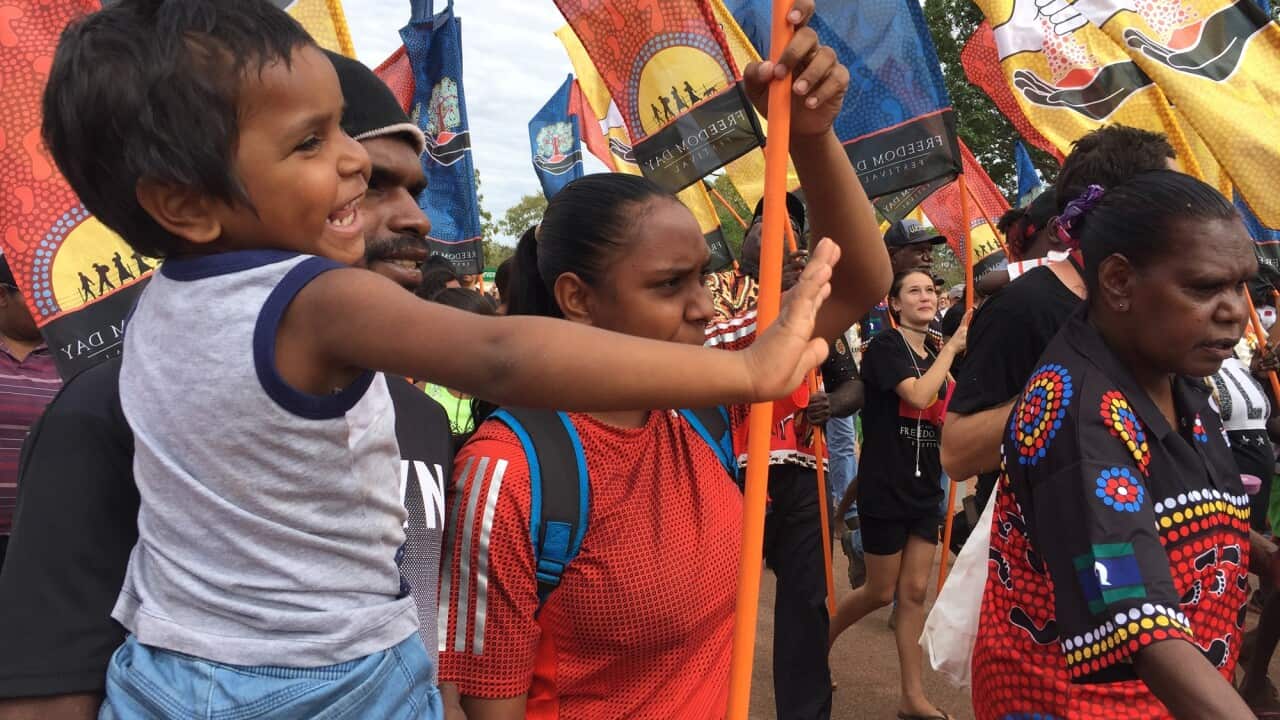 Marchers celebrate the 50th anniversary Wave Hill Walk-off holding flags in August 2016.