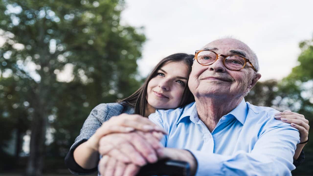Portrait of senior man and his granddaughter in a park