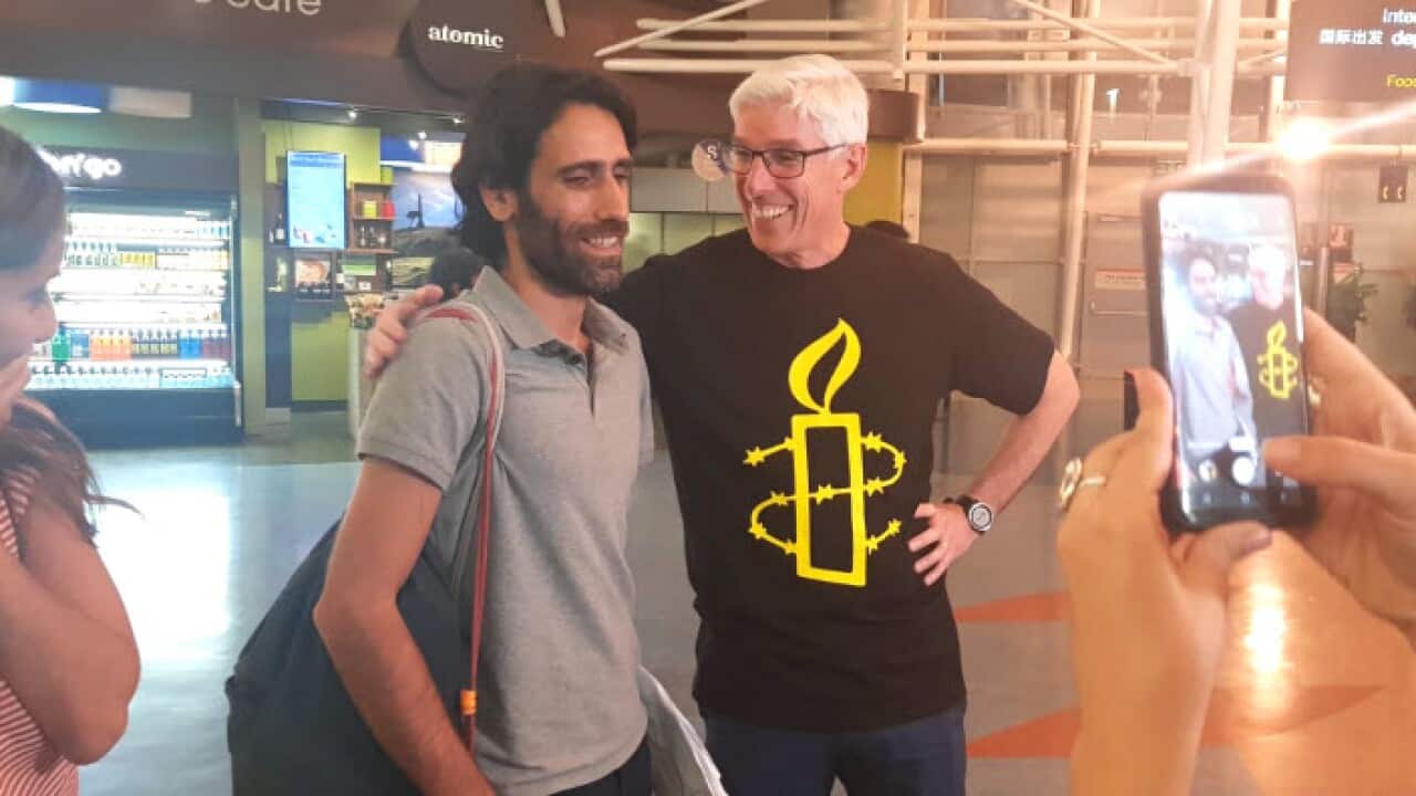 Dr Graham Thom (right) with Behrouz Boochani at Auckland airport