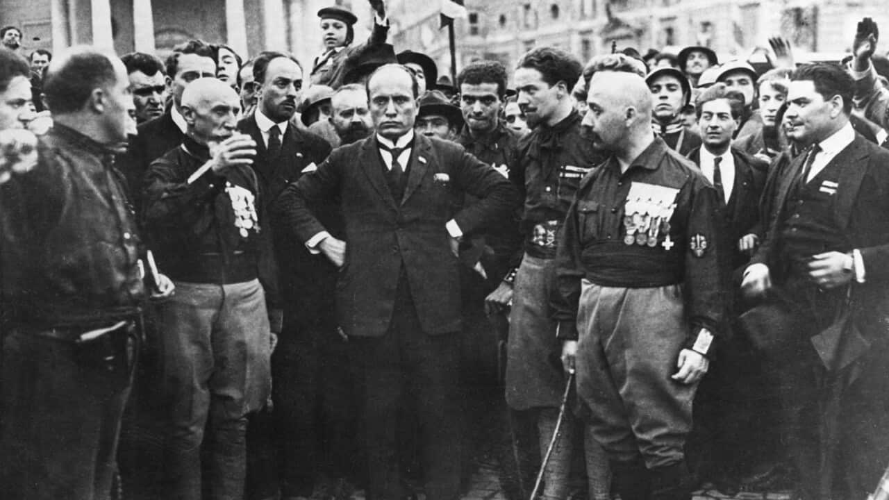 Benito Mussolini with fascist crowd around him marching in Rome