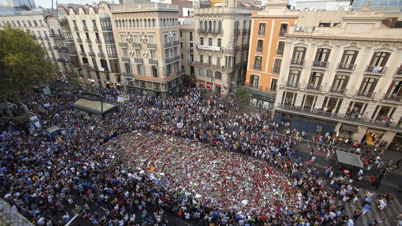 People at a memorial tribute of flowers and messages on Barcelona's historic Las Ramblas promenade at the end of a demonstration condemning the attacks.
