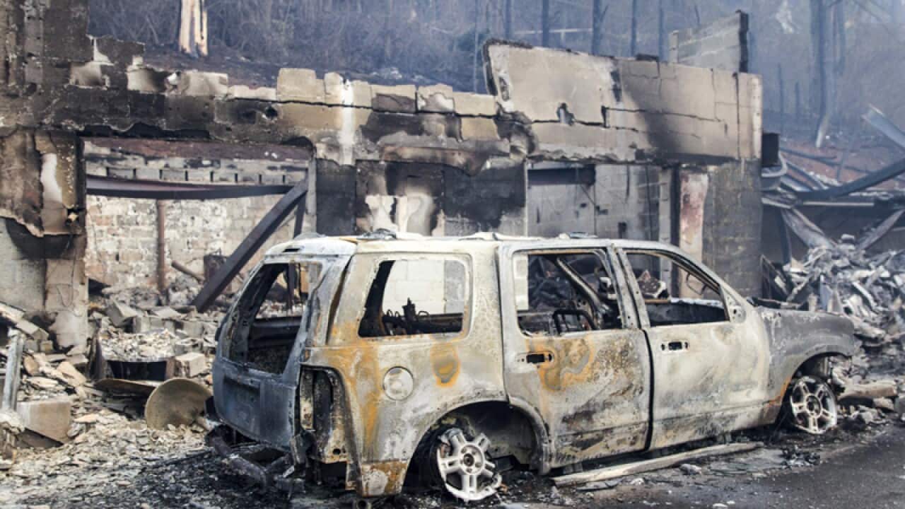 A scorched vehicle next to a burned out building in Gatlinburg