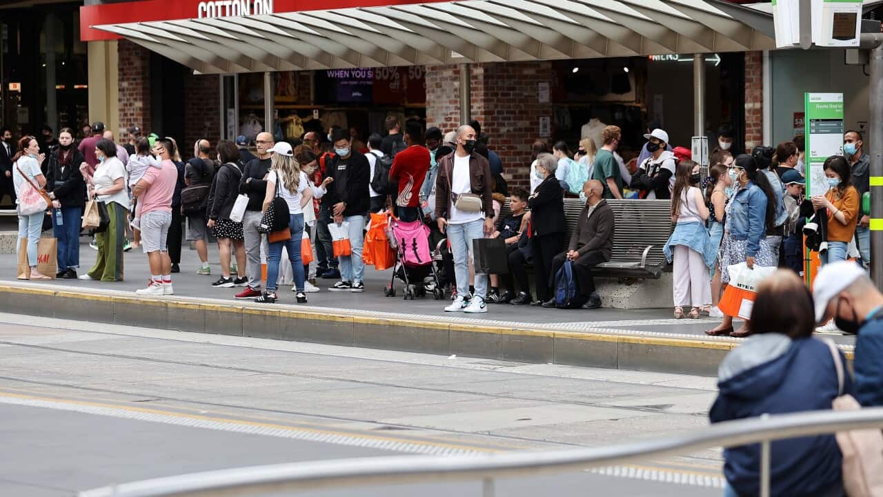 People are seen at a tram stop in Melbourne, Monday, December 27, 2021. (AAP Image/Con Chronis) NO ARCHIVING