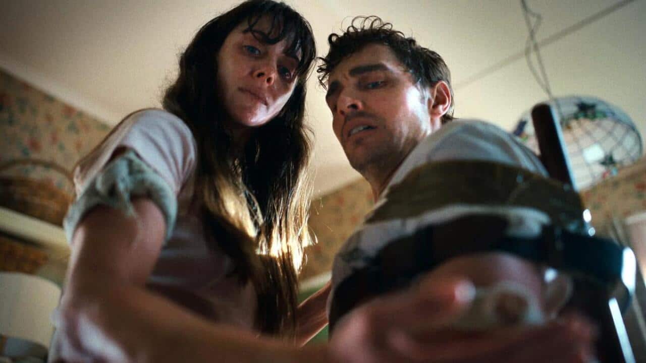 A woman and a man look at the camera.