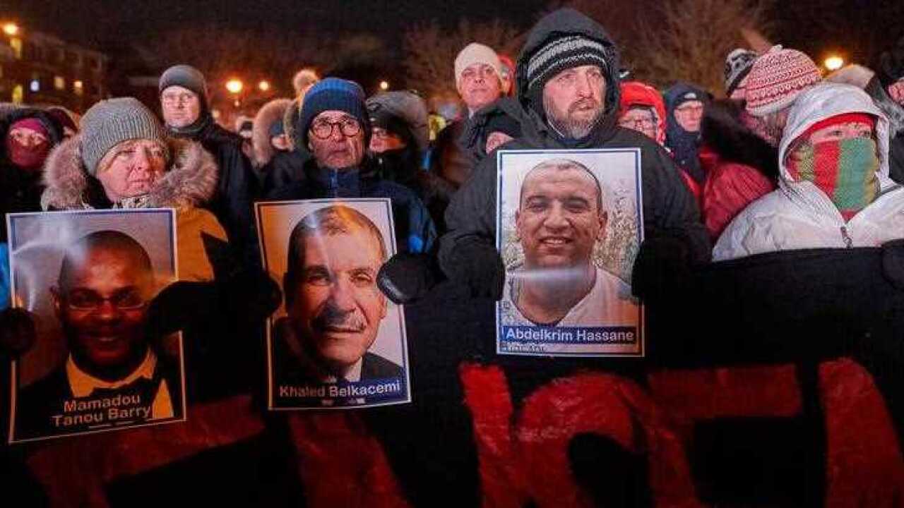 People hold pictures of victims while attending a vigil and prayer ceremony for the victims of the Islamic Cultural Centre of Quebec City shooting,