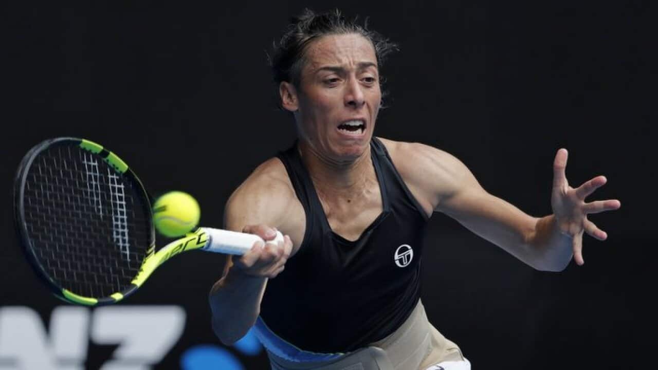 Francesca Schiavone of Italy makes a forehand return to Latvia's Jelena Ostapenko during their first round match at the Australian Open tennis championships in Melbourne, Australia, Monday, Jan. 15, 2018. (AP Photo/Vincent Thian)