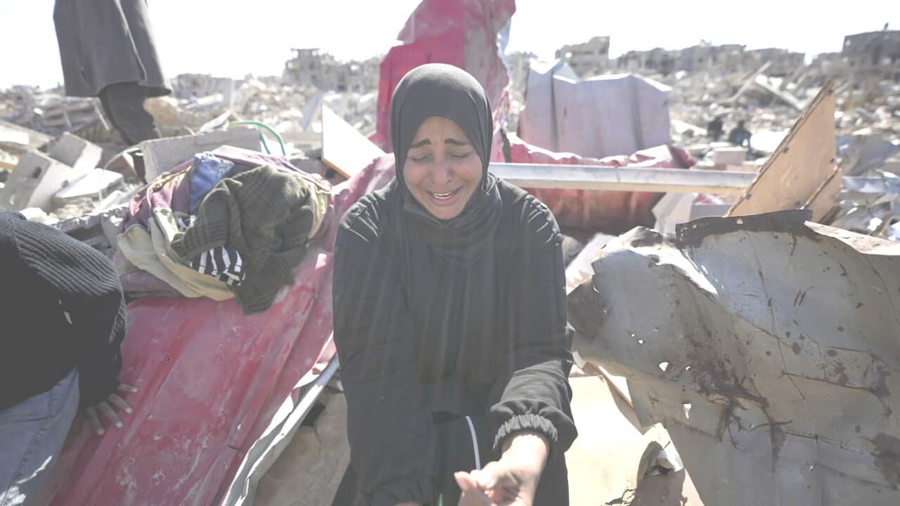 A woman sitting in the ruins of her home