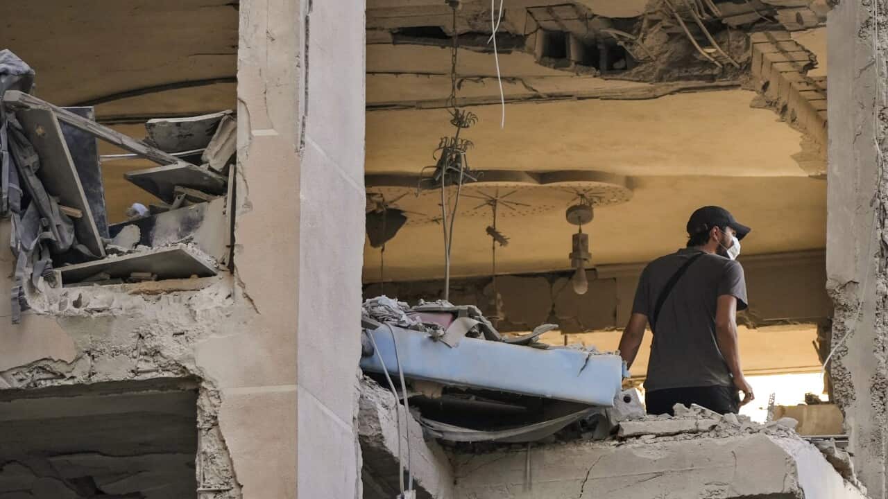 A person inspects their apartment after damage from an airstrike.