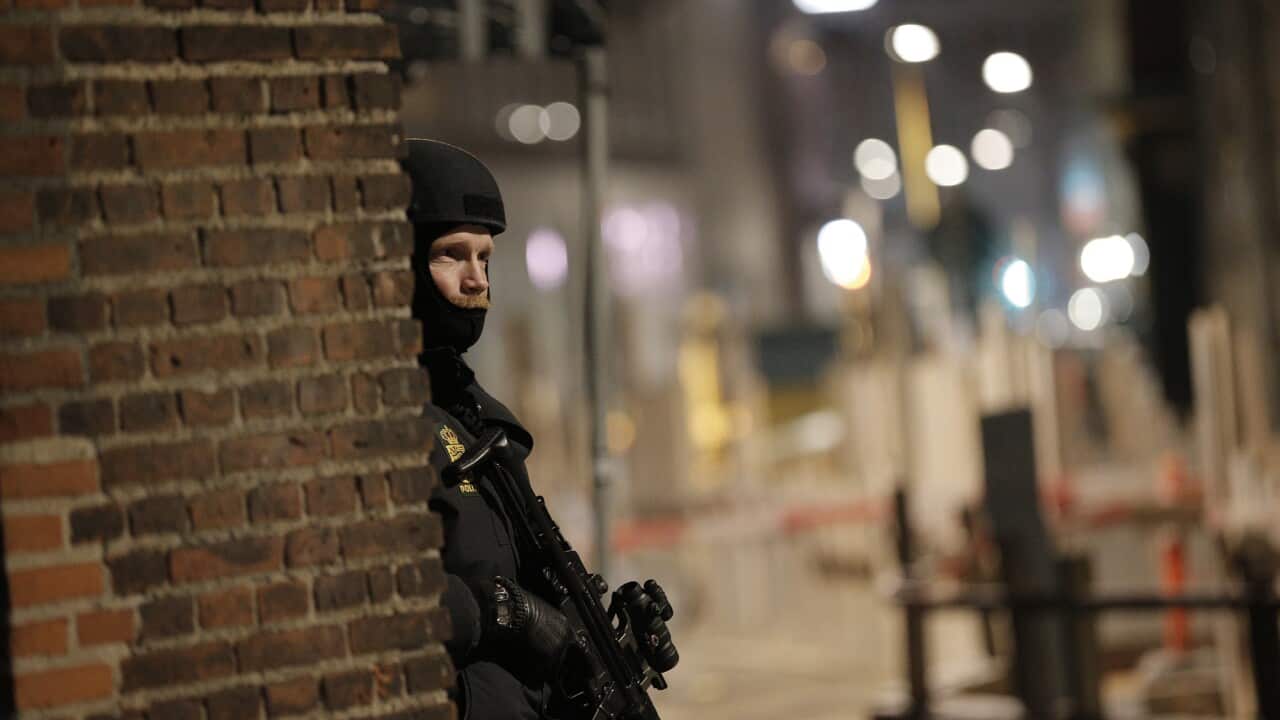 A police officer stands his post on the streets of central Copenhagen on February 15, 2015 after one person was shot in the head and two policemen were shot in the arm and leg in Krystalgade, a street that is home to Copenhagen's main synagogue.
