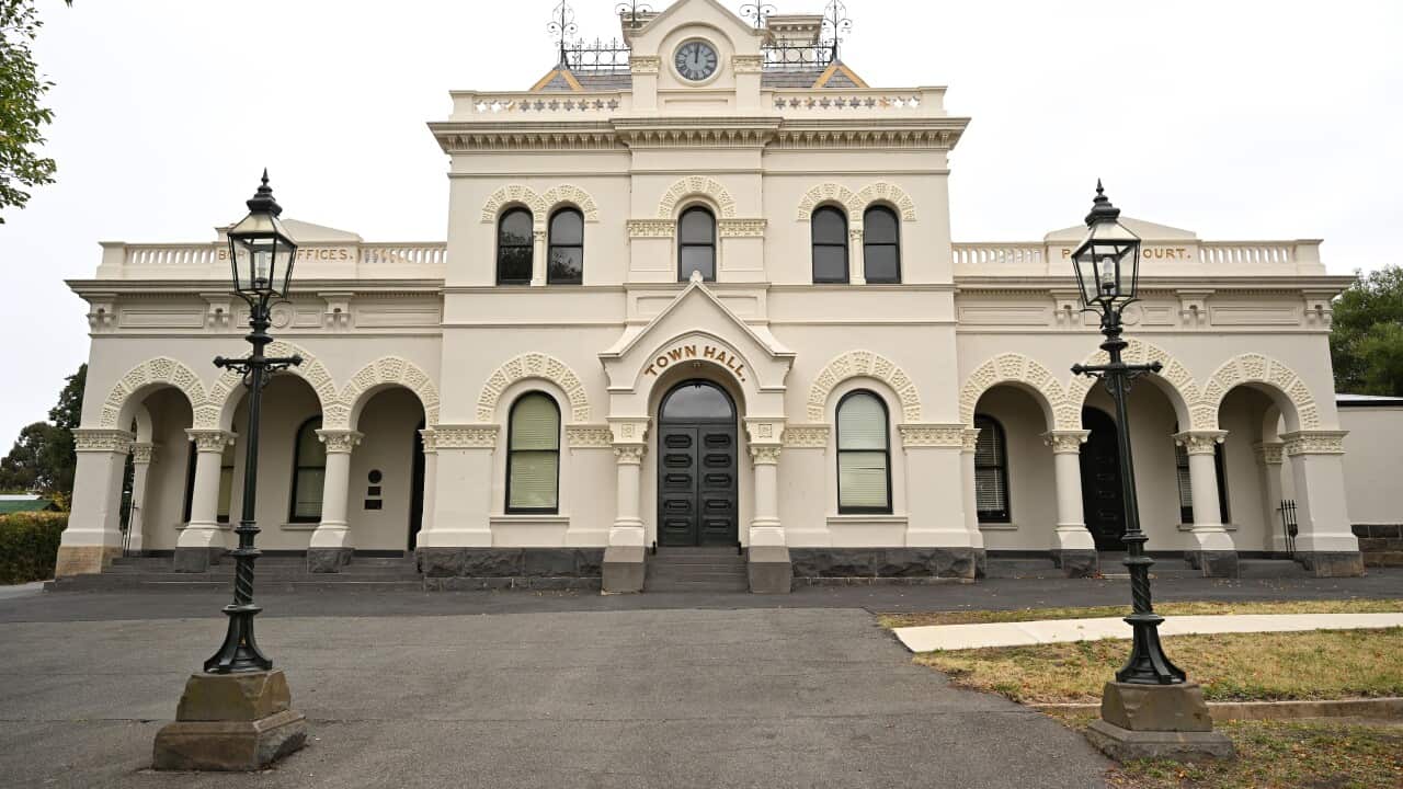 The Clunes Town Hall, a grand Victorian-era cream-coloured building, is seen from the front.