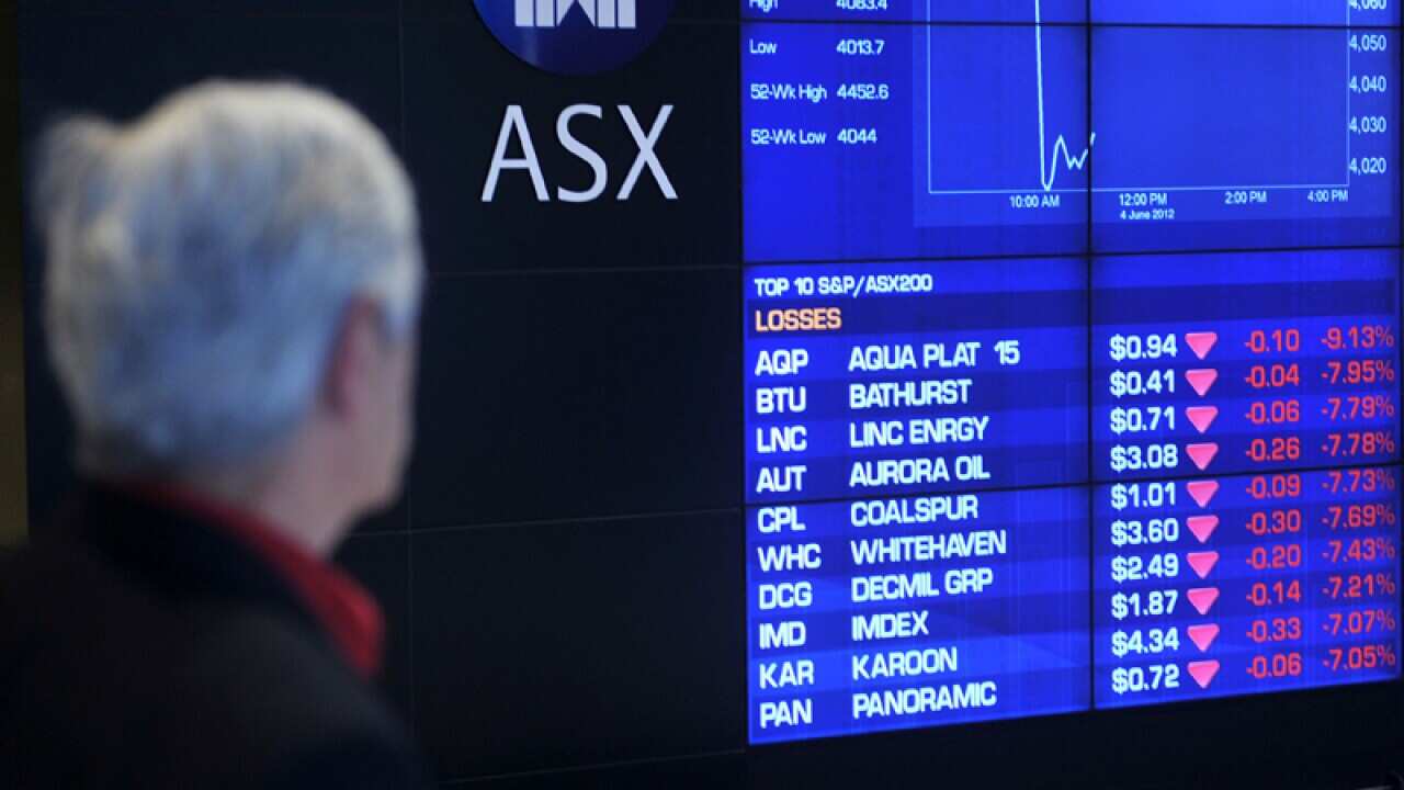 A bystander looks on at the sharemarket figures
