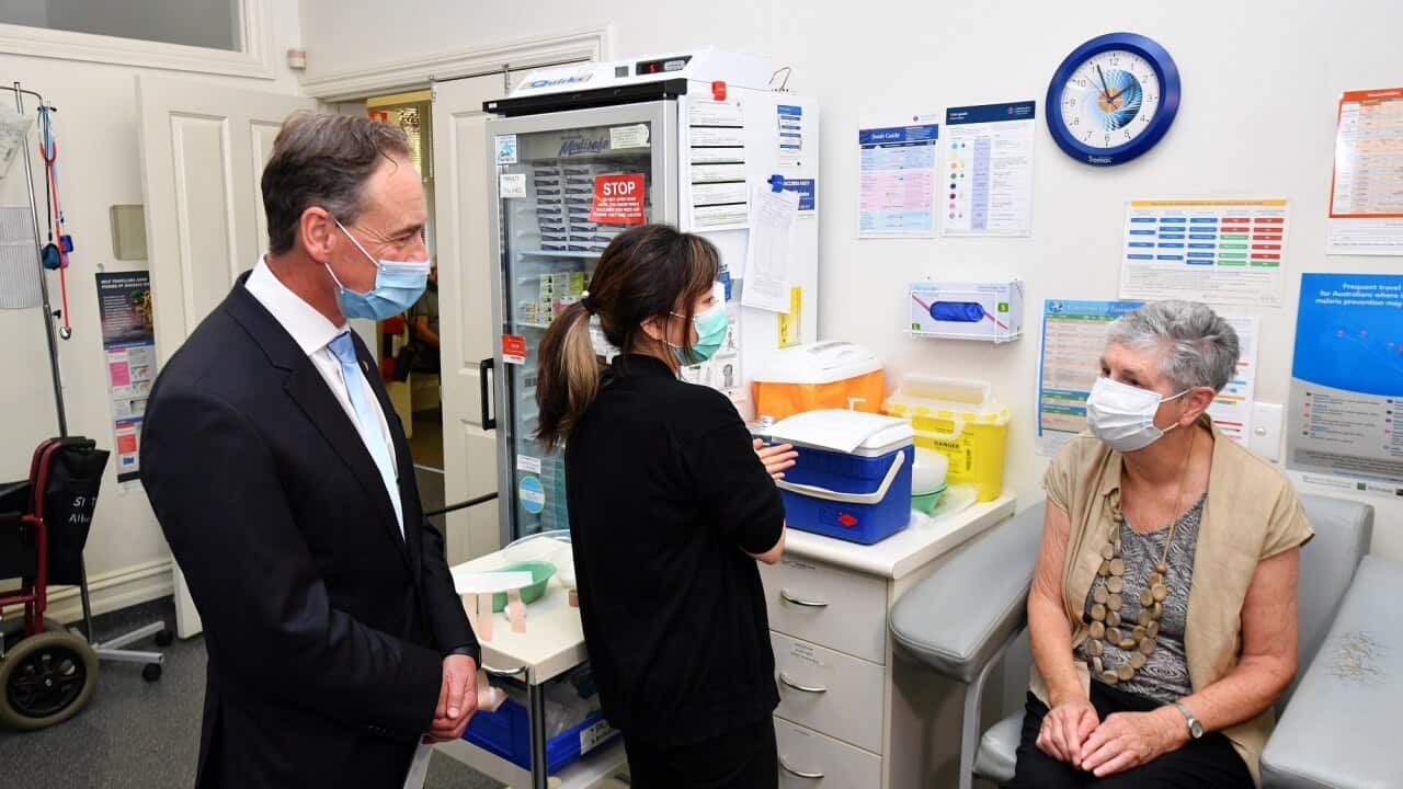 Federal Health Minister Greg Hunt speaks to patient Anne Hyslop before she receives vaccination at Albert Park Medical Centre in Melbourne on April 7, 2021.