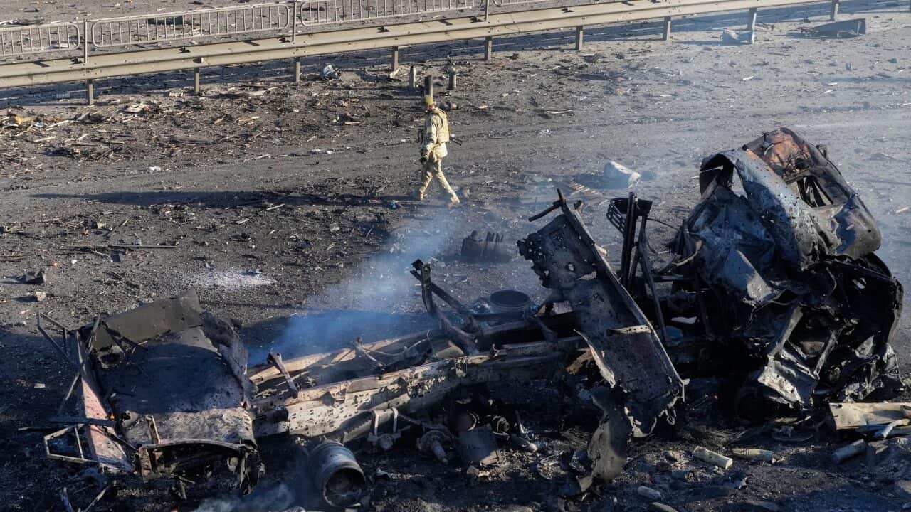 A Ukrainian soldier walks past debris of a burning military truck, on a street in Kyiv, Ukraine, Saturday, Feb. 26, 2022. (AP Photo/Efrem Lukatsky)
