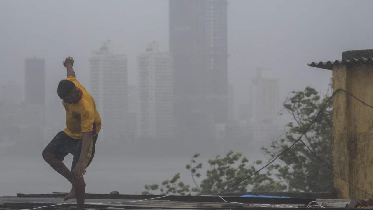 A man looses his balance due to heavy wind and rain as cyclone Nisarga barrels towards India's western coast at Worli Koliwada on June 3, 2020 in Mumbai, India.