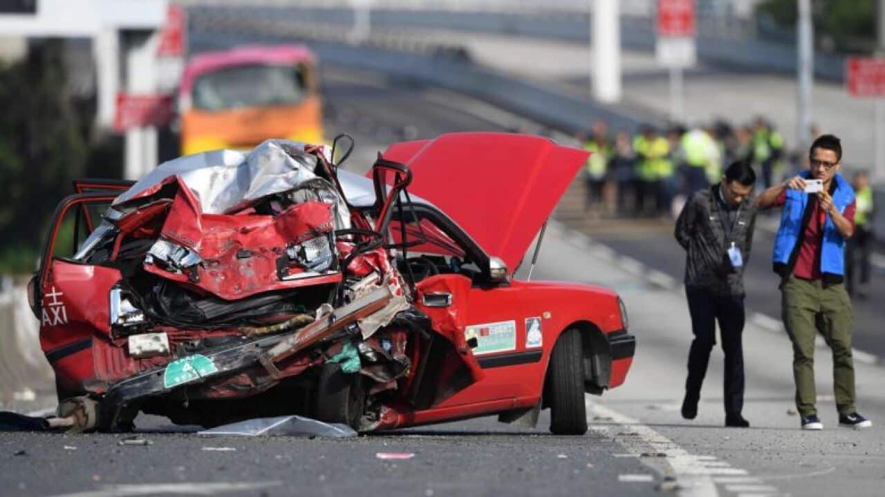 Police take photos of a crushed taxi after a coach collided with it in Hong Kong, on Nov 30, 2018.