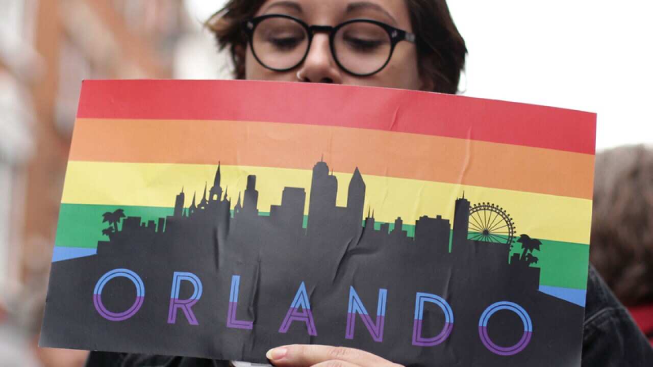 A woman holding an Orlando placard