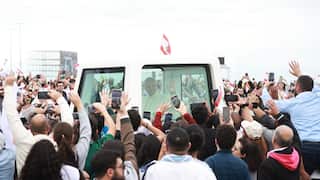 Pope Leo XIV in the popemobile surrounded by throngs of people