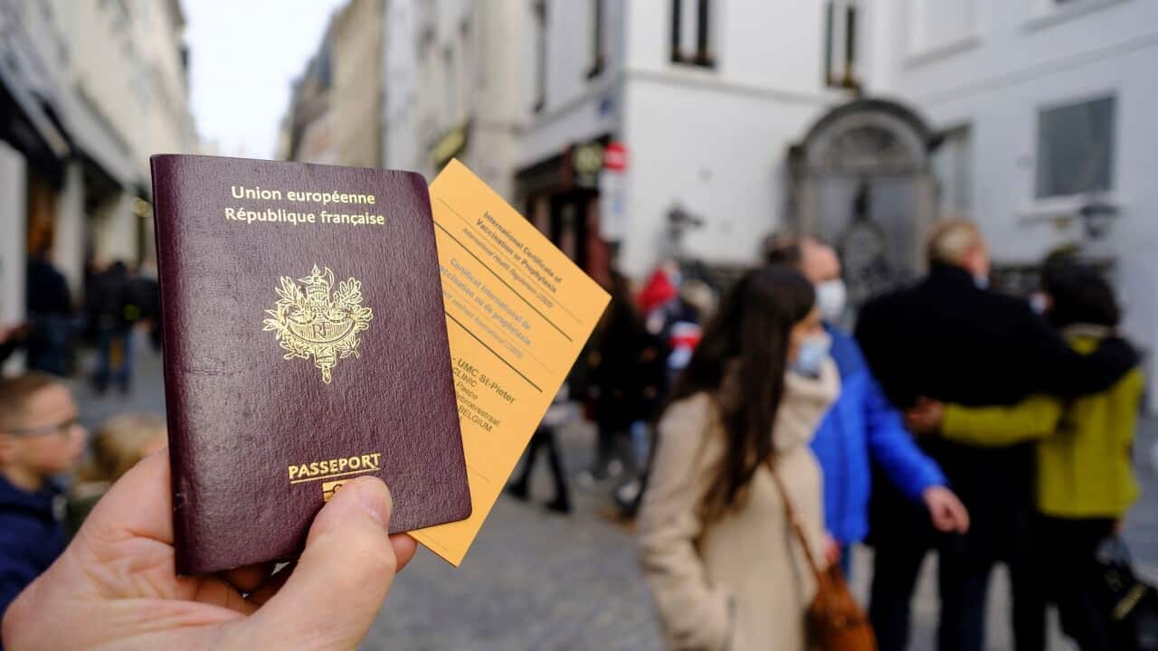 A French passeport and an International Certificate of Vaccination or Prophylaxis are seen in an illstration pictures on February 19, 2021 in Brussels, Belgium. Back is the famous statue of the Manneken-Pis. - Photo by Monasse T/ANDBZ/ABACAPRESS.COM.