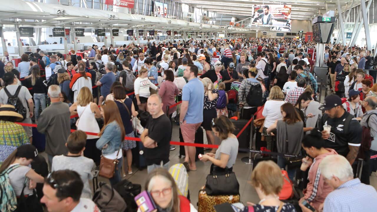 A mass group of people queuing for help at an airport terminal