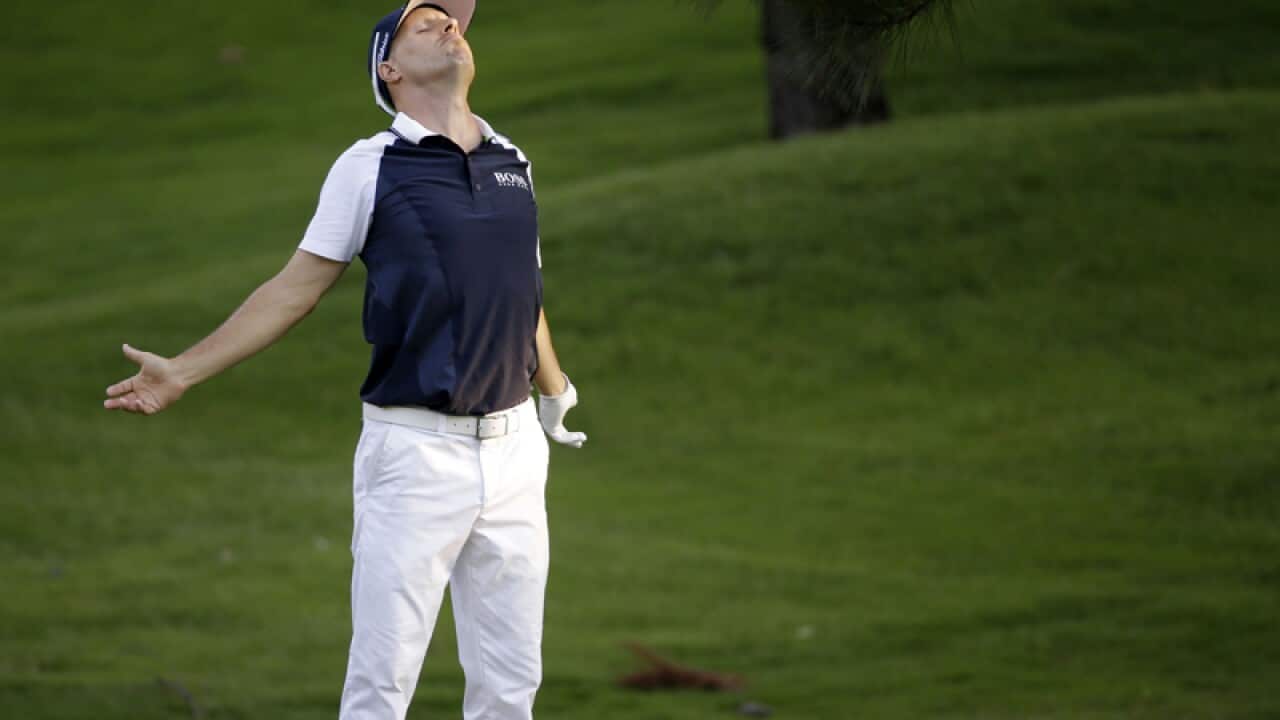 Ben Crane stretches as he waits for his turn to hit