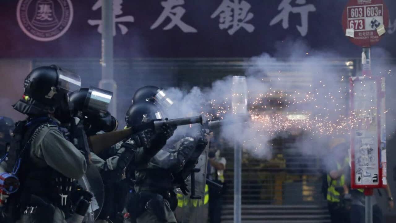 In this Saturday, Nov. 2, 2019, file photo, police in riot gear fire tear gas during a protest in Hong Kong