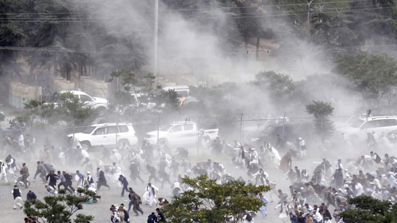 People running from an explosion during a funeral in Kabul