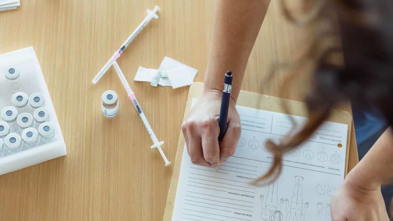 A healthcare worker filling out a medical chart