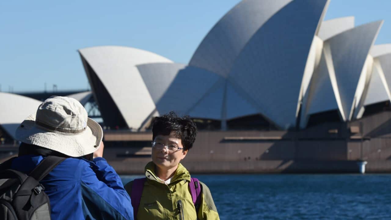Chinese tourists take photographs on Sydney Harbour
