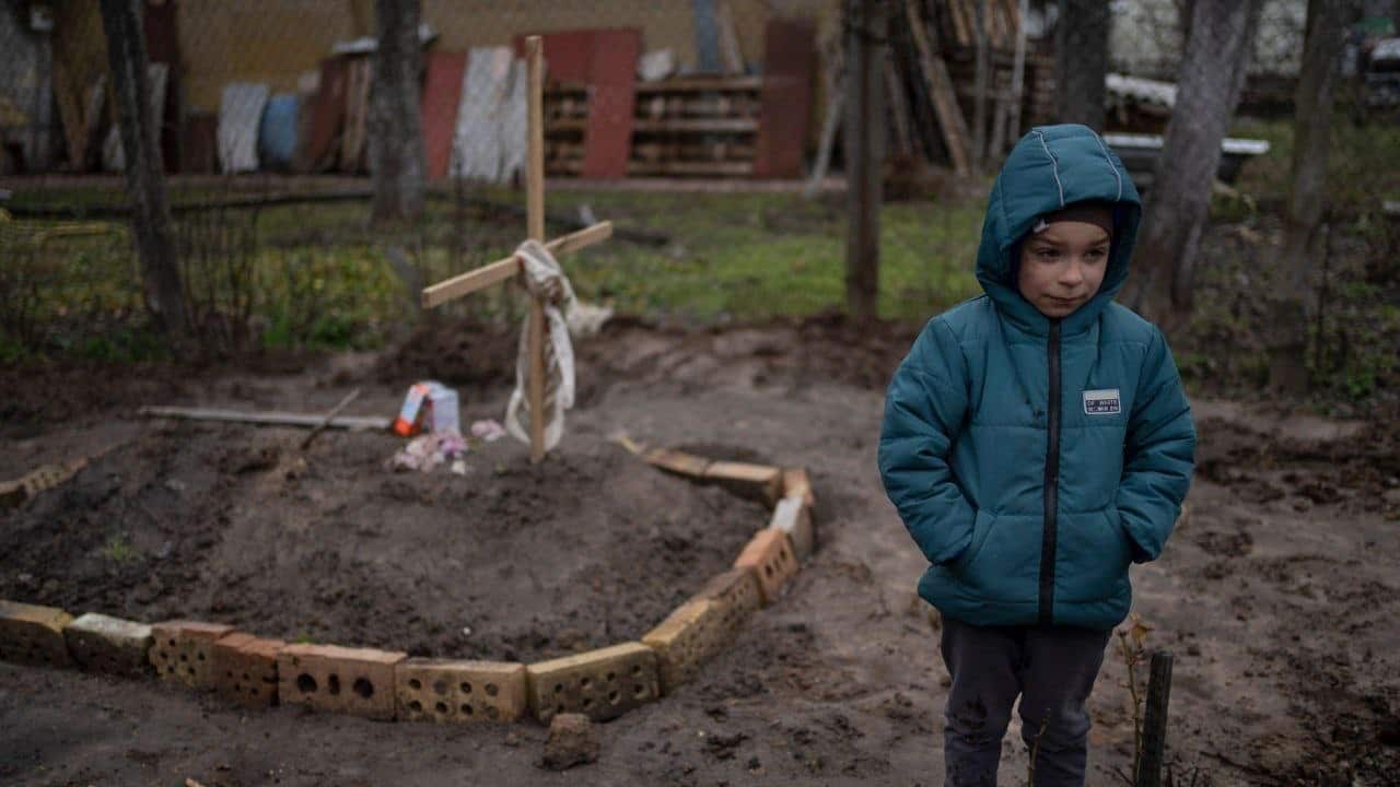 Bucha-Kyiv-region-A-6-year-old-boy-stands-near-the-grave-of-his-mother-buried-in-their-yard.jpg