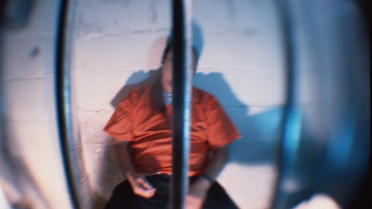Prisoner behind bars of cell