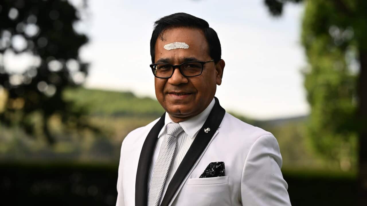Indian-Australian paediatrician Dr Angraj Khillan in a white suit.